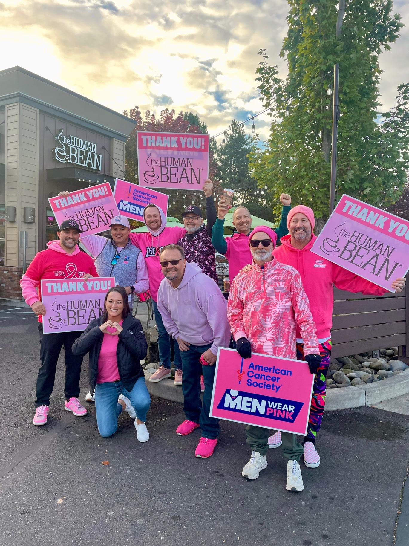 Men Wear Pink of Lane County ambassadors holding thank-you signs outside The Human Bean